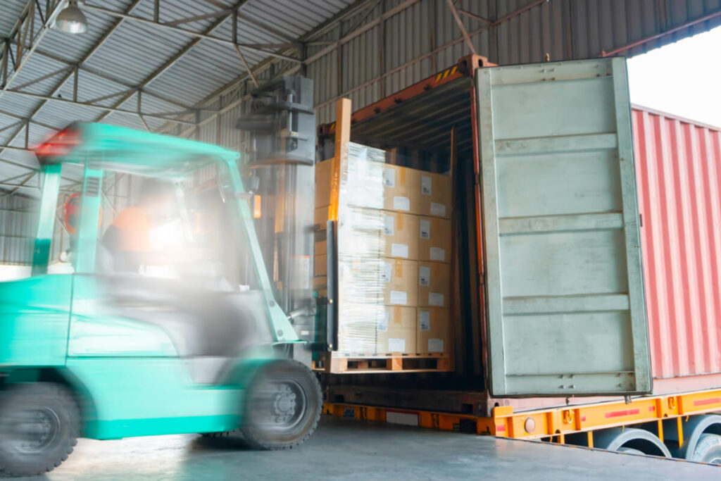 Forklift loading palletised freight into shared international shipping container for cost-effective LCL freight consolidation by B2B Freight Solutions