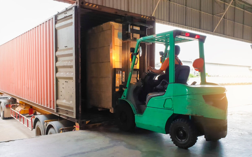 Forklift operator loading mixed cargo into container for LCL freight consolidation to minimise shipping costs – B2B Freight Solutions